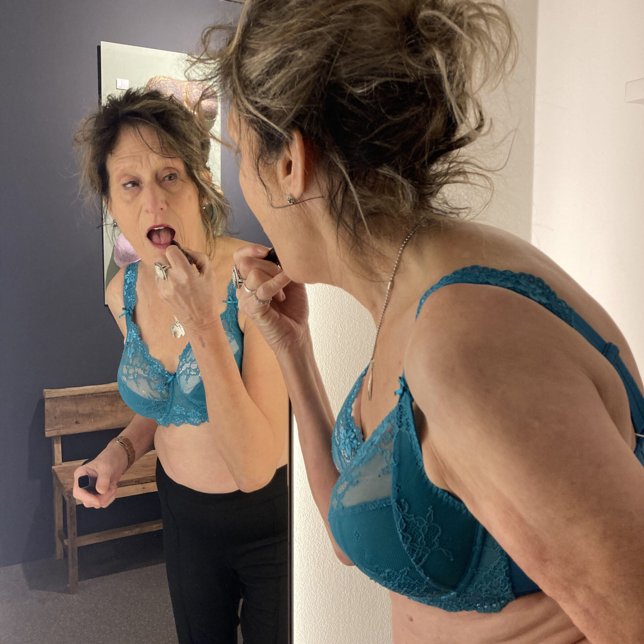 eine Frau in einem Kleidungsstück, die in einen Spiegel schaut